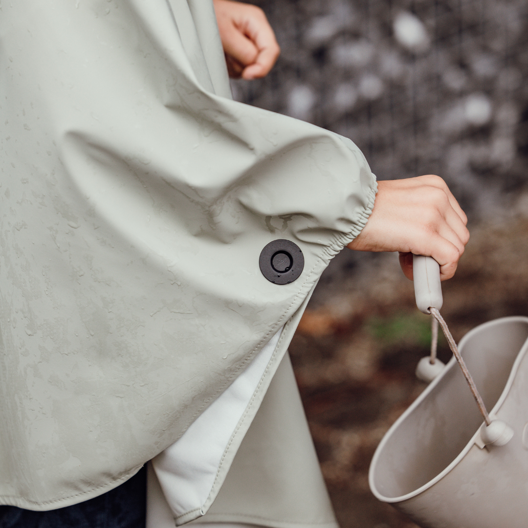 Detailaufnahme des Magnetknopfs am Arm eines Kinderponchos – elastischer Saum für optimalen Sitz.