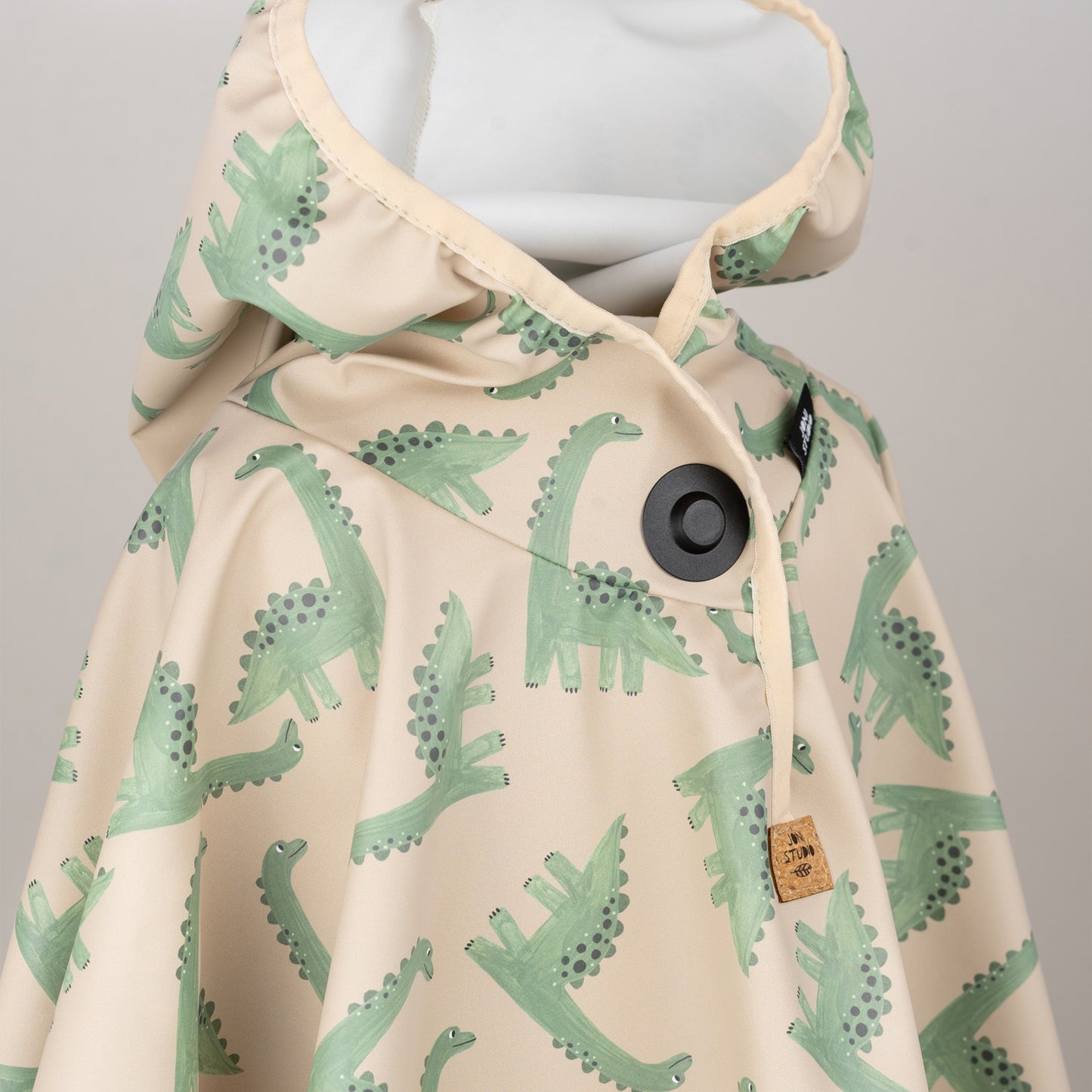 Regenponcho mit Kapuze, grünem Dino-Muster und sichtbarem Magnetknopf – praktische Kinderregenbekleidung von Joni Studio