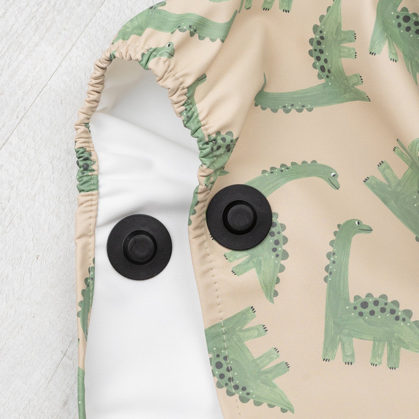Elastischer Ärmelabschluss mit Magnetknopf – funktionales Detail des Dino-Regenponchos für Kinder von Joni Studio