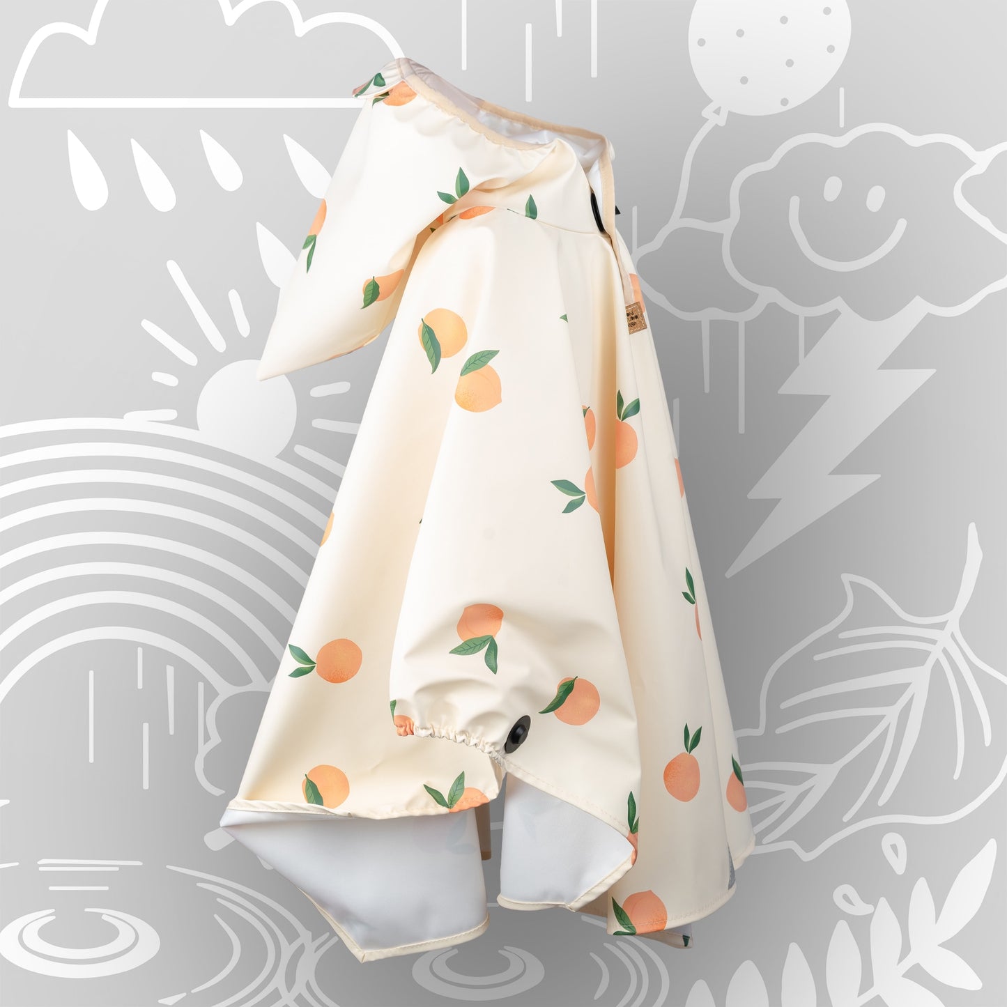 Kinderregenponcho mit Orangenmuster in Seitenansicht – Kapuze mit Zipfel und Magnetknopf-Verschluss vorne, elastischer Ärmelabschluss, wasserabweisend.